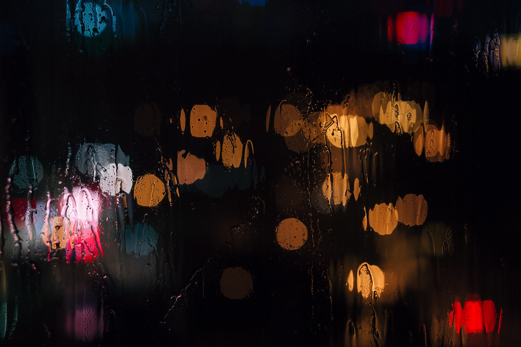 City lights through a rain streaked window at night